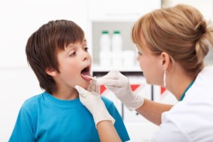 Doctor consulting a young boy - sore throat concept